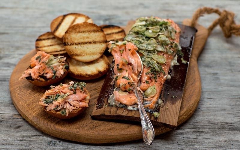Rosa Lachs auf einer Zedernholzplanke mit gerösteten Brotscheiben